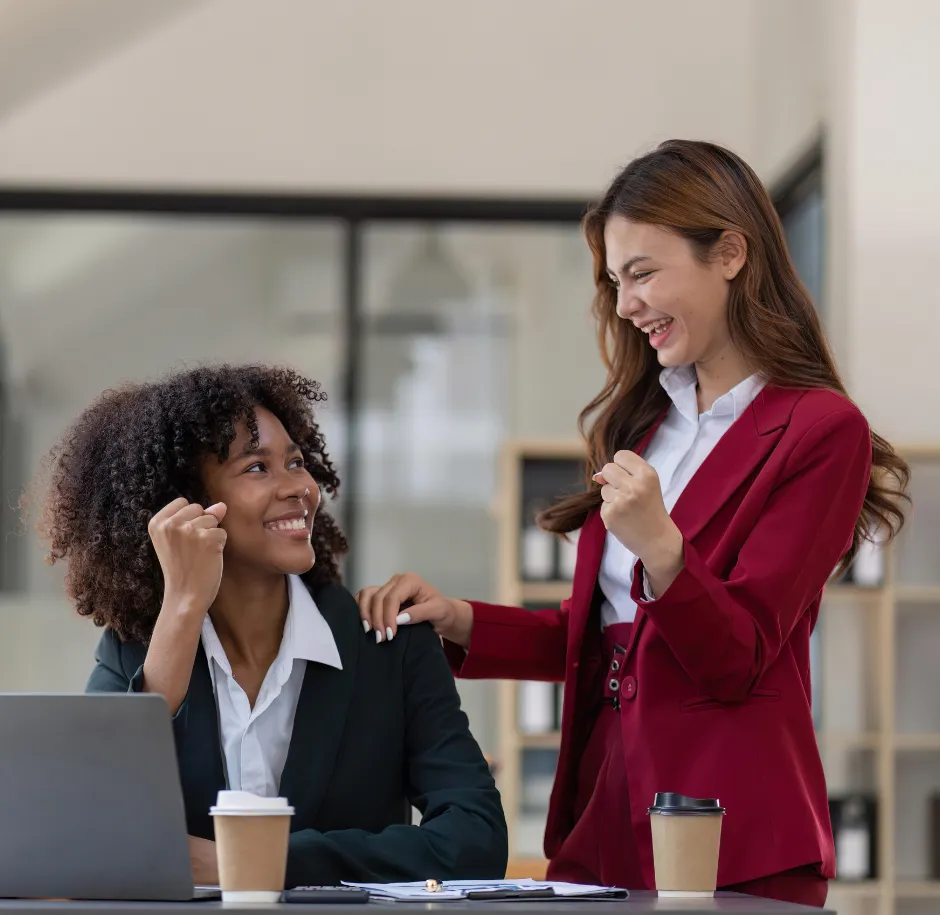 Two colleagues celebrating together at a desk